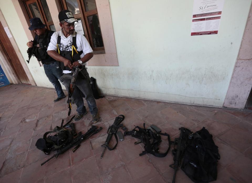 Vigilantes or members of the community police stand together after disarming several municipal police officers in Paracuaro in Michoacan state