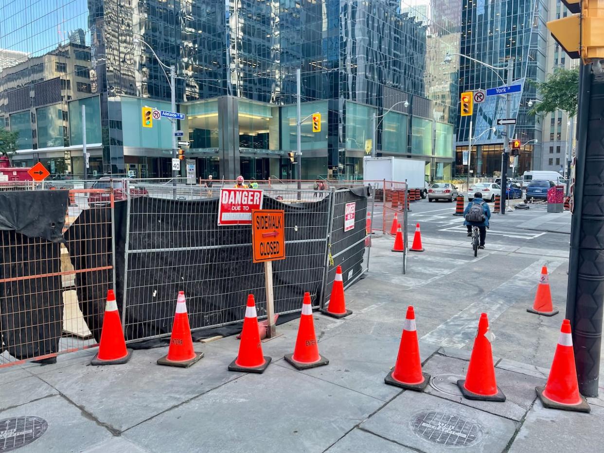 Traffic restrictions are in place at the intersection of Adelaide and York streets downtown, pictured here, as crews install TTC streetcar tracks. The city says a second intersection closure at Adelaide Street W. and Bay Street will be in effect starting Monday. (Mehrdad Nazarahari/CBC - image credit)