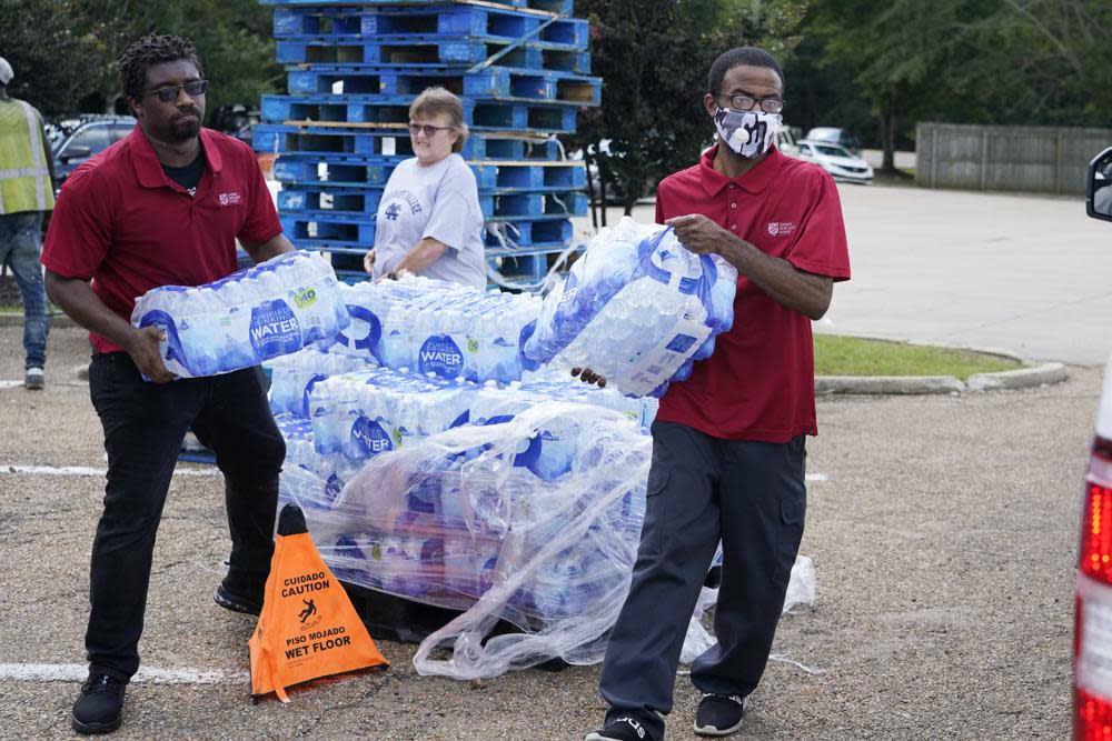 Salvation Army members carry cases of water to a waiting vehicle in Jackson, Miss., Wednesday, Aug. 31, 2022. (AP Photo/Rogelio V. Solis)