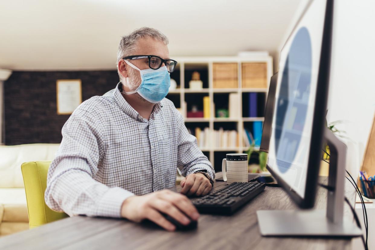 Business man working from home, wear a protective mask. Quarantine due coronavirus pandemic. Stay at home.