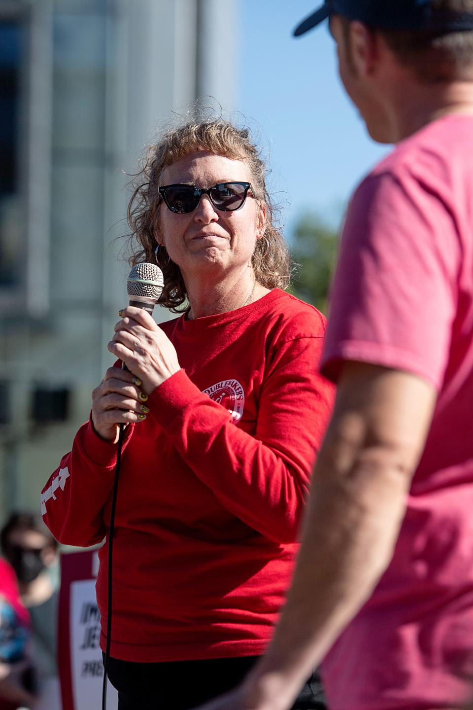 Jen Hampton, of Asheville Food and Beverage Workers United, introduces Welcker Taylor, president of the Asheville Fire Fighters Association, during a May Day rally at Pack Square, May 1, 2024.