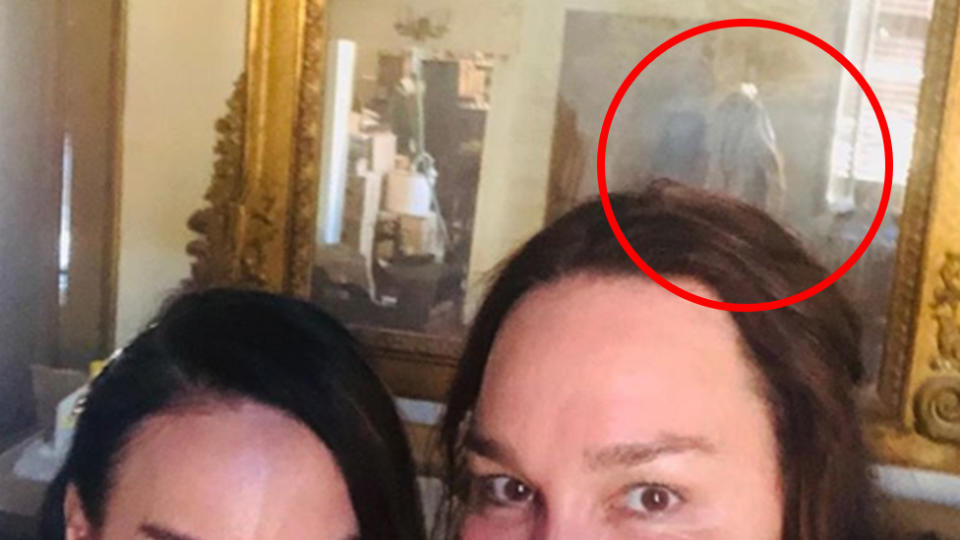 A selfie of radio host Kate Langbroek and her friend that shows a ghostly figure in the background.