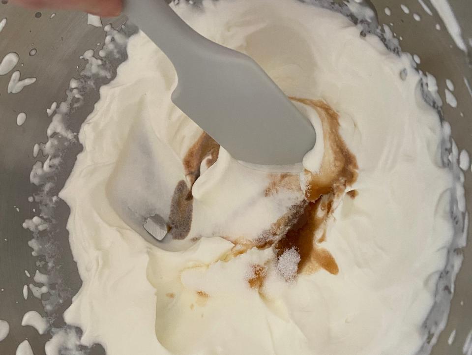 hand stirring homemade whooped cream with a silicone spatula