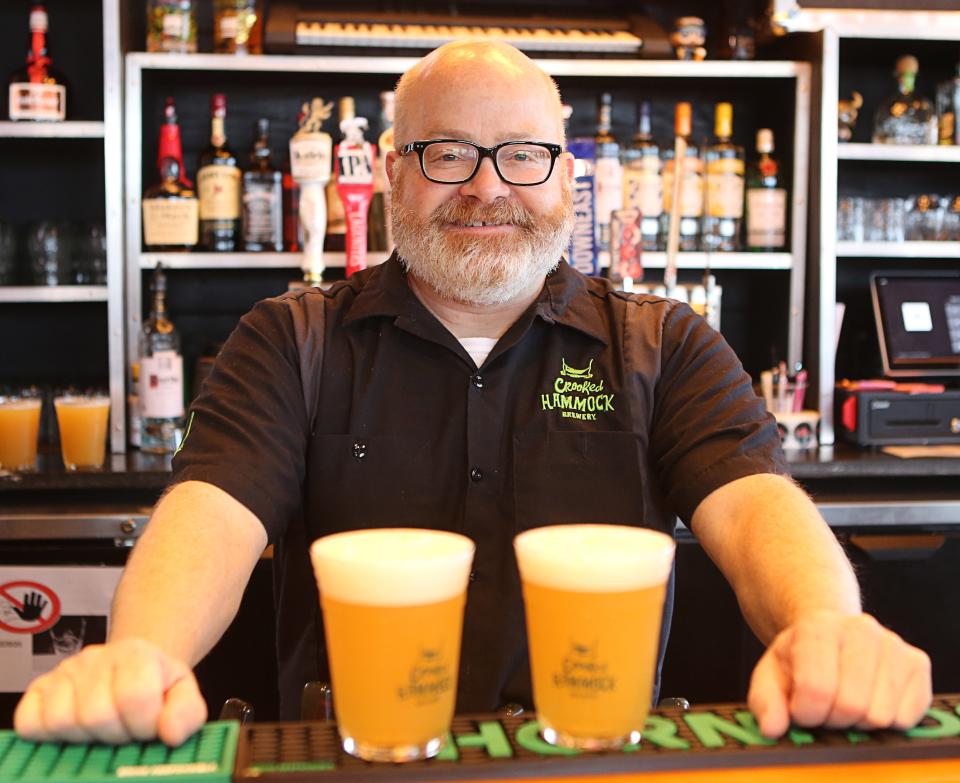 Larry Horwitz, with Crooked Hammock Brewery, poses with two glasses of Joint Collaboration IPA. The beer is made with cannabis terpenes. While it gives the beer a marijuana flavor, it won't get you high.