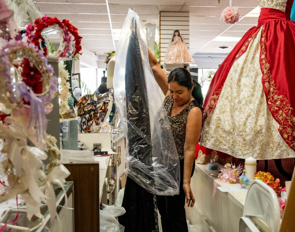 Virginia Leon, store owner of Variedades Elisa, helps prepare a dress for a customer on Tuesday July 16, 2024 in Milwaukee, Wis.