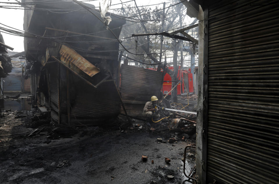 A firefighter douses the burning wreckage of a shop at a tyre market after it was set on fire by a mob in a riot affected area after clashes erupted between people demonstrating for and against a new citizenship law in New Delhi, India, February 26, 2020. REUTERS/Adnan Abidi