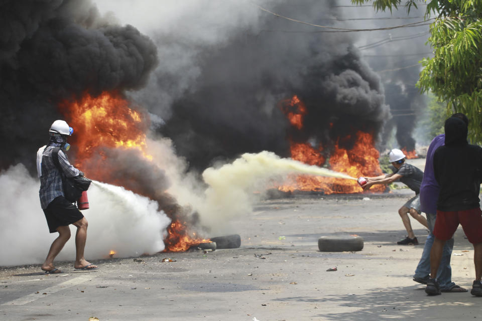 Anti-coup protesters extinguish fires during a protest in Thaketa township Yangon, Myanmar, Saturday, March 27, 2021. The head of Myanmar’s junta on Saturday used the occasion of the country’s Armed Forces Day to try to justify the overthrow of the elected government of Aung San Suu Kyi, as protesters marked the holiday by calling for even bigger demonstrations. (AP Photo)