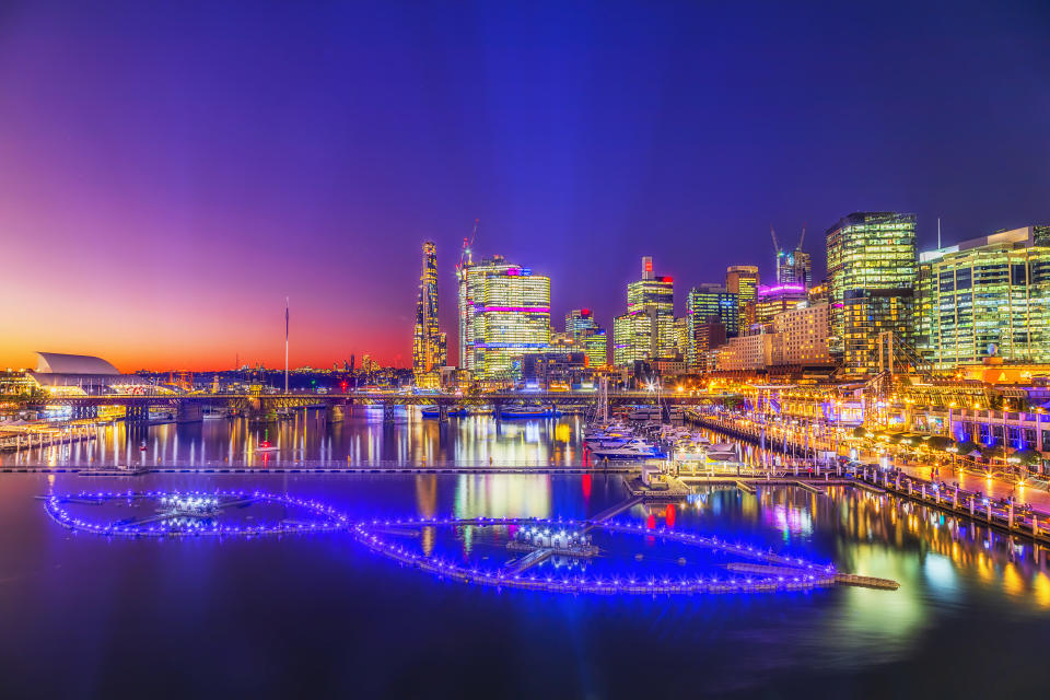 Darling Harbour City of Sydney CBD waterfront high-rise buildings at sunset with bright lights.