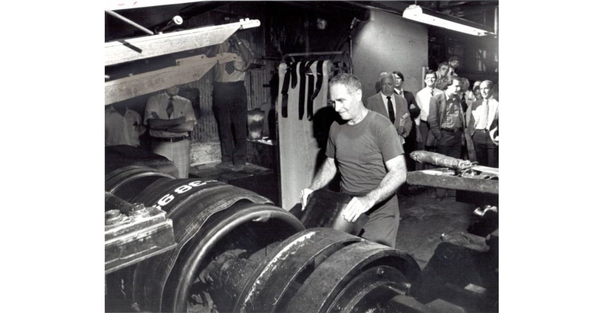 Firestone employee Julius Garman building the last tire in Firestone's Plant 1. The company closed the plant after 70 years in June 1981.