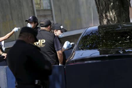 Forensic technicians inspect the car where Guatemalan lawyer Francisco Palomo was shot dead in Guatemala City, June 3, 2015. REUTERS/Jorge Dan Lopez