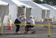 People cheer after getting a vaccine at the Disneyland Resort serving as a Super POD (Point Of Dispensing) COVID-19 mass vaccination site Wednesday, Jan. 13, 2021, in Anaheim, Calif. California is immediately allowing residents 65 and older to get scarce coronavirus vaccines, Gov. Gavin Newsom announced Wednesday. (AP Photo/Damian Dovarganes)