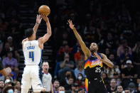 Orlando Magic guard Jalen Suggs (4) shoots a 3-pointer over Phoenix Suns forward Mikal Bridges (25) during the first half of an NBA basketball game Saturday, Feb. 12, 2022, in Phoenix. (AP Photo/Ross D. Franklin)