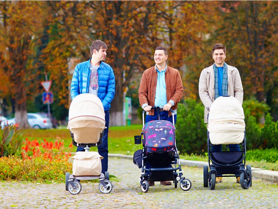 Fathers pushing strollers in a park