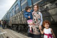 A migrant woman with her children board a train, after crossing the Greek-Macedonian border, near Gevgelija, on October 9, 2015