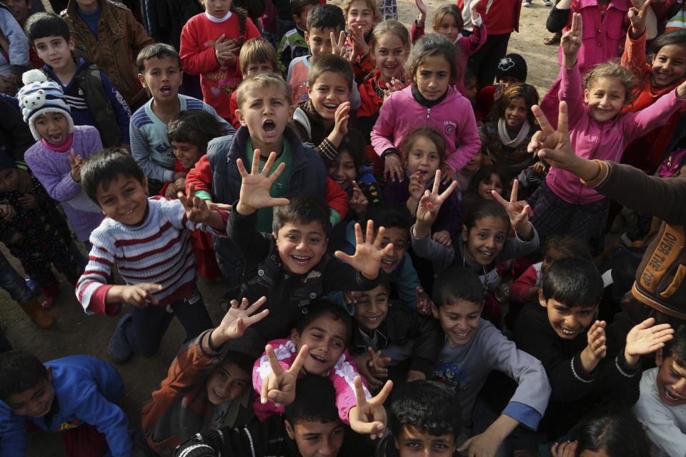 Iraqi internally displaced children cheering during a New Year's celebration at the Hassan Sham camp, east of Mosul, Iraq, Saturday, Dec 31, 2016. (AP Photo/ Khalid Mohammed)