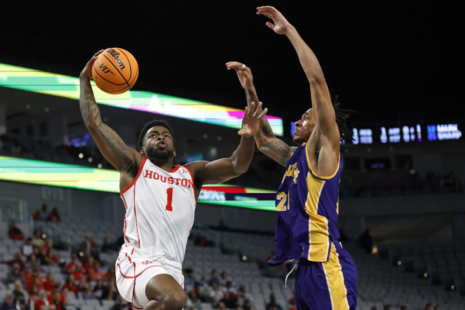 Houston guard Jamal Shead (1) goes to the basket as East Carolina guard Jaden Walker (21) defends during the first half of an NCAA college basketball game in the quarterfinals of the American Athletic Conference Tournament, Friday, March 10, 2023, in Fort Worth, Texas. (AP Photo/Ron Jenkins)