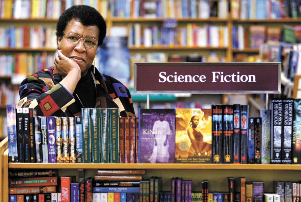 FILE - In this Feb. 4, 2004 file photo, science fiction writer Octavia Butler poses for a portrait near some of her novels at University Book Store in Seattle, Wash. On Friday, March 5, 2021, scientists announced that they’ve named the touchdown site of the Perseverance Mars rover in honor of the late writer, who grew up next door to the Jet Propulsion Laboratory in Pasadena. She was one of the first African Americans to receive mainstream attention for science fiction. (Joshua Trujillo/seattlepi.com via AP)