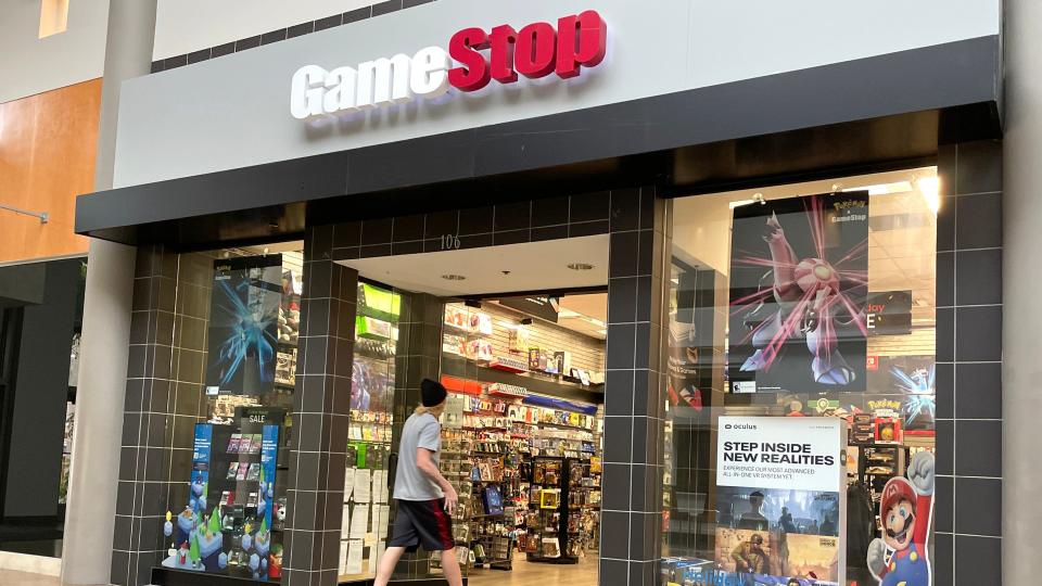 A young man walks into a GameStop video game store.