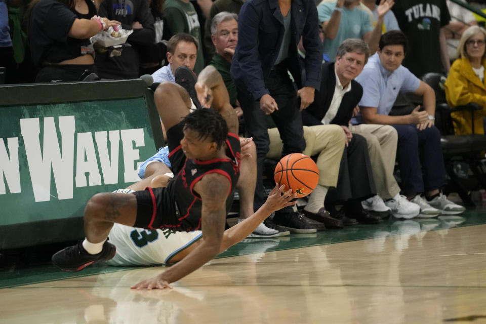 Tulane guard Jalen Cook (3) and Houston guard Jamal Shead battle for a loose ball as they tumble out of bounds during the second half of an NCAA college basketball game in New Orleans, Tuesday, Jan. 17, 2023. (AP Photo/Gerald Herbert)