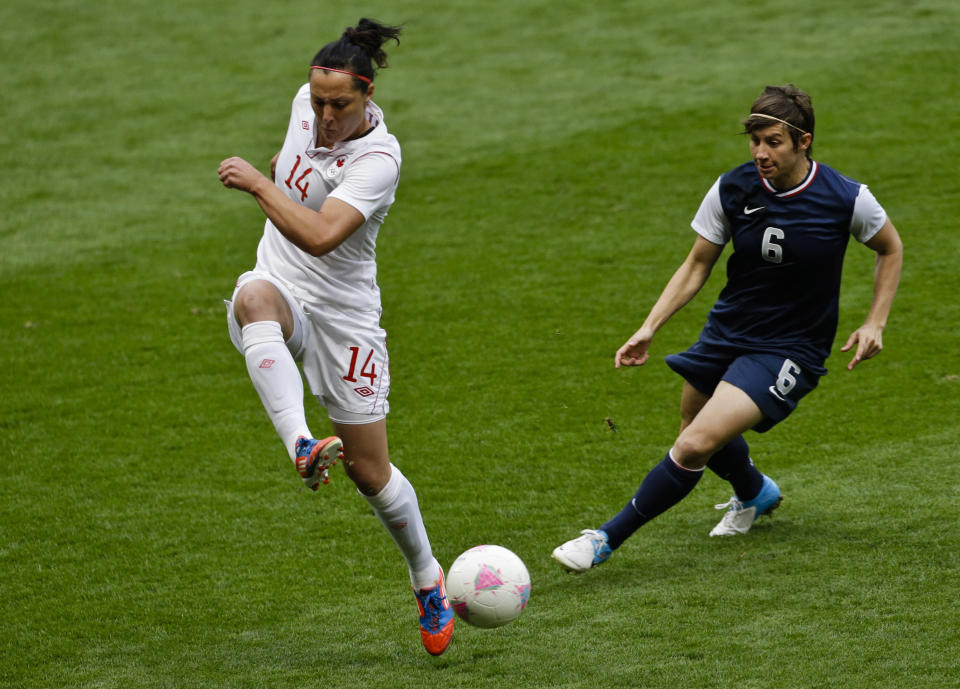 United States' Abby Wambach, left, takes the ball from Canada's Kaylyn Kyle during the semifinal women's soccer match between the USA and Canada in the 2012 Summer Olympics, Monday, Aug. 6, 2012, at Old Trafford in Manchester, England. (AP Photo/Ben Curtis)