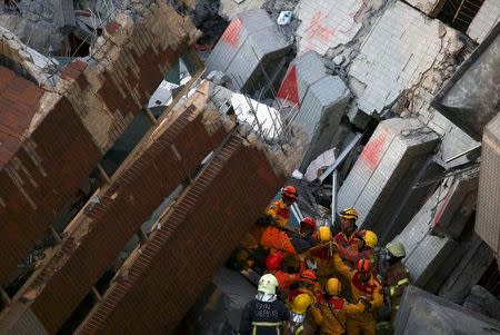 Rescuers carry a survivor out from the site where a 17-storey apartment building collapsed after an earthquake hit Tainan, southern Taiwan, February 8, 2016. REUTERS/Tyrone Siu