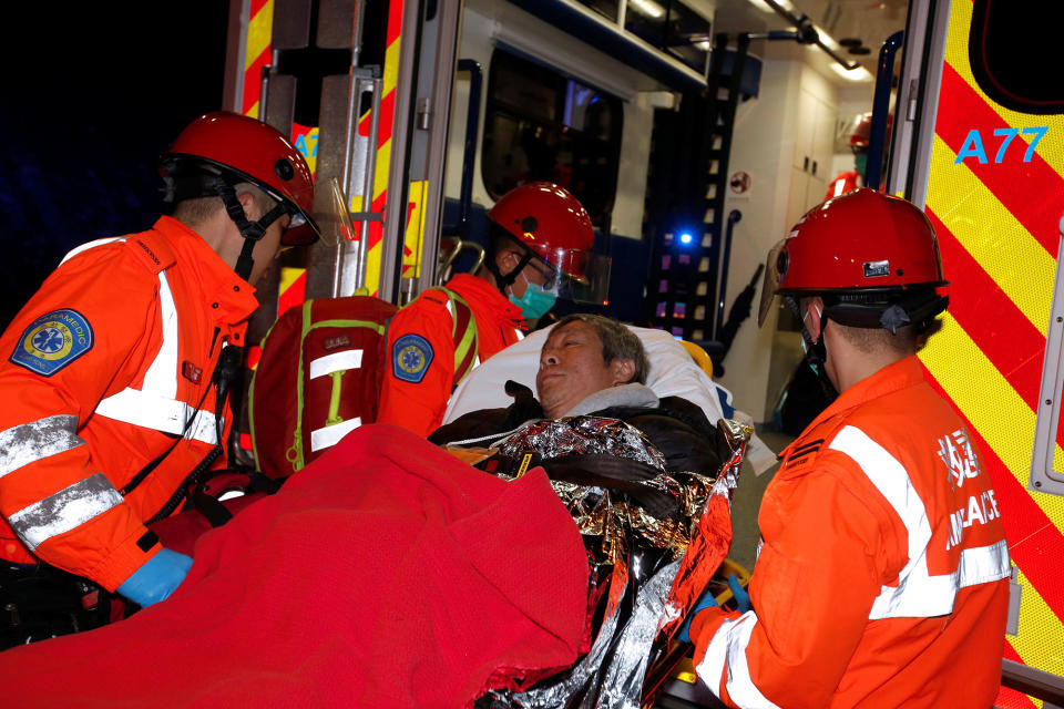 <p>Rescuers carry an injured person after a bus crashed in Hong Kong, China, Feb. 10, 2018. (Photo: Bobby Yip/Reuters) </p>