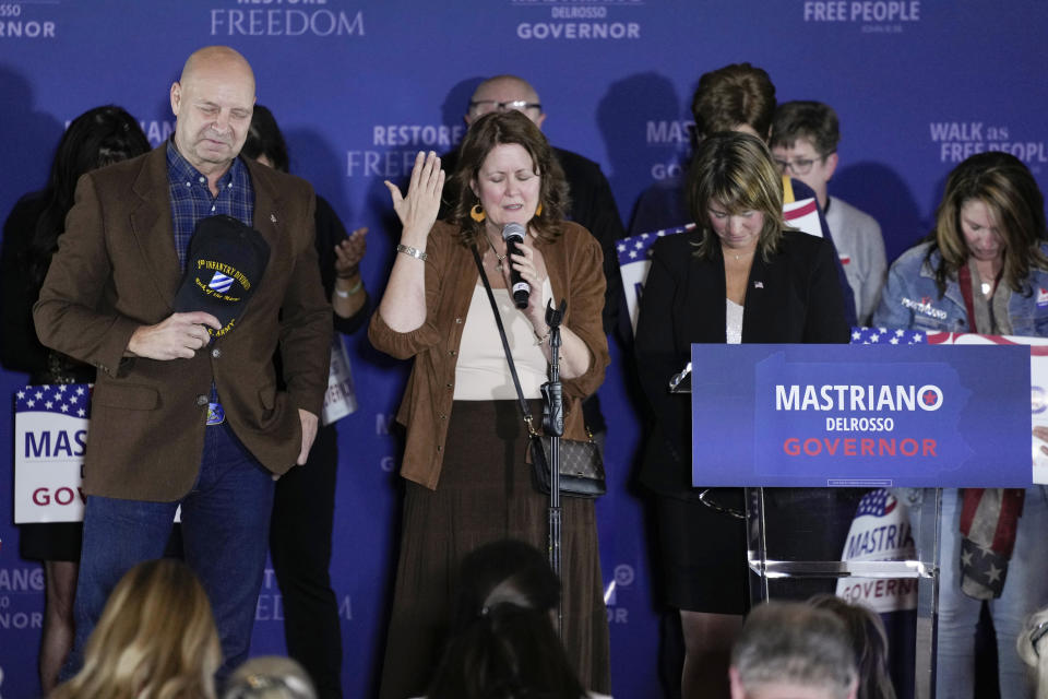 Pennsylvania Republican gubernatorial candidate Doug Mastriano, his wife Rebecca Mastriano, and running mate Carrie Lewis DelRosso pray on stage with supporters during his election night campaign gathering at the Penn Harris Hotel in Camp Hill, Pa., Tuesday, Nov. 8, 2022. Democrat Josh Shapiro won the race for governor of Pennsylvania. (AP Photo/Carolyn Kaster)