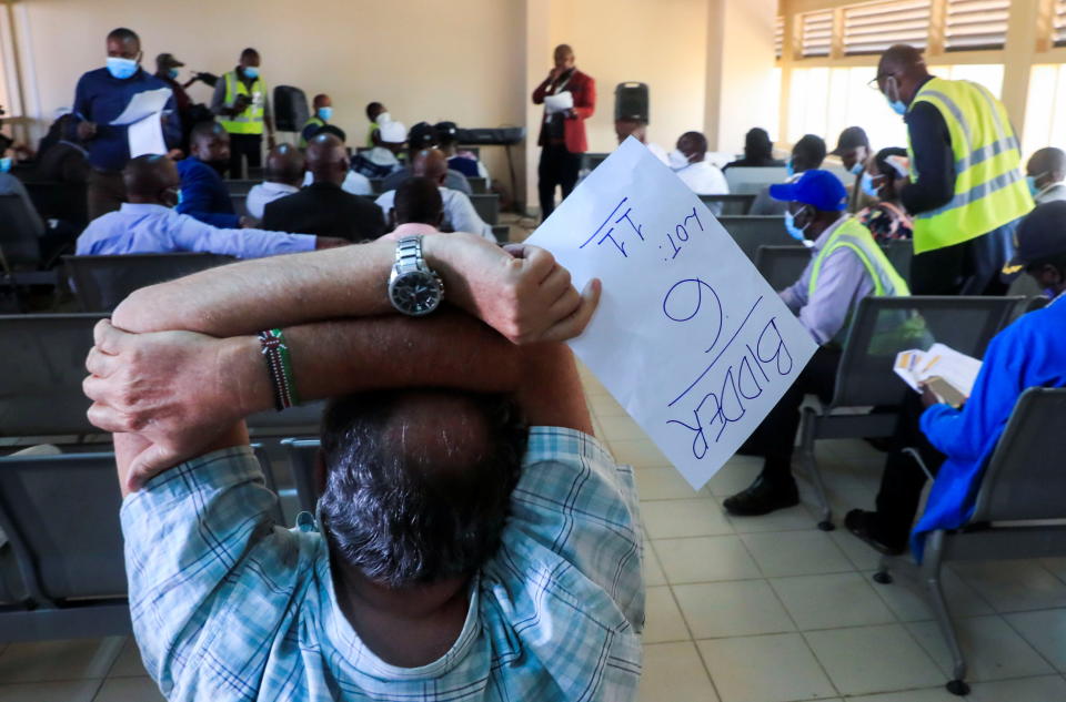 David Winston holds his bid during the auction of planes by the Kenya Airports Authority after previous owners abandoned them at the Jomo Kenyatta International Airport in Nairobi, Kenya, November 17, 2021. REUTERS/Thomas Mukoya