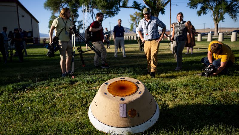 Journalists gather around a rehearsal model of the sample return capsule on the OSIRIS-REx spacecraft at Dugway Proving Grounds on Thursday, July 20, 2023. NASA and military personnel have been using the model as they prepare for the Sept. 24 reentry of the actual sample return capsule currently onboard the OSIRIS-REx spacecraft, which collected samples from the asteroid Bennu.