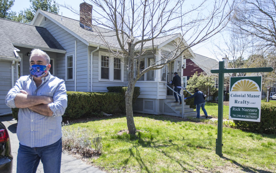 REVERE, MA - MAY 2: Rick Nazarro of Colonial Manor Realty waits in the driveway as a couple enters a property he is trying to sell during a &quot;controlled&quot; open house on May 2, 2020 in Revere, MA. Nazarro says he gets there early to open every door and wipe down all surfaces so interested buyers don't have to touch anything, also he only lets one party in at a time encouraging others to practice social distancing. (Photo by Blake Nissen for The Boston Globe via Getty Images)