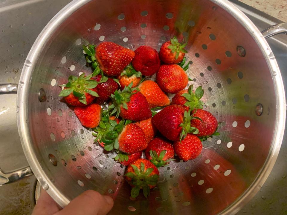 strawberries in a collander after being washed