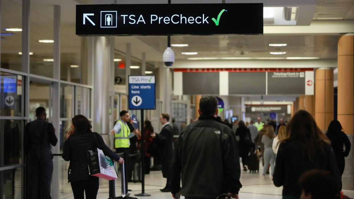  Travelers head to the TSA PreCheck line at an airport. 