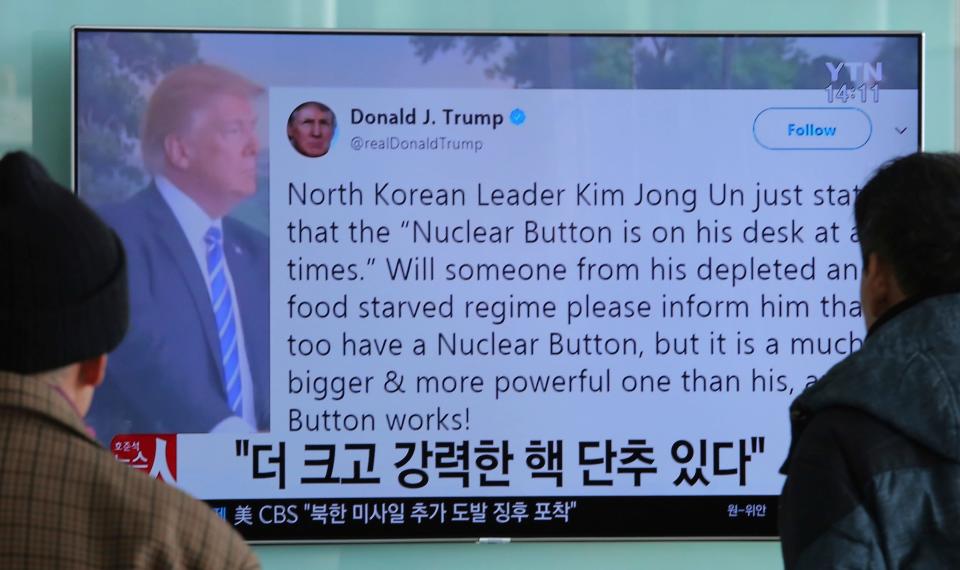 Passersby watch a news program showing a Twitter post from President Donald Trump on North Korea's nuclear weapons program, at Seoul Railway Station in Seoul, South Korea, on Jan. 3, 2018.