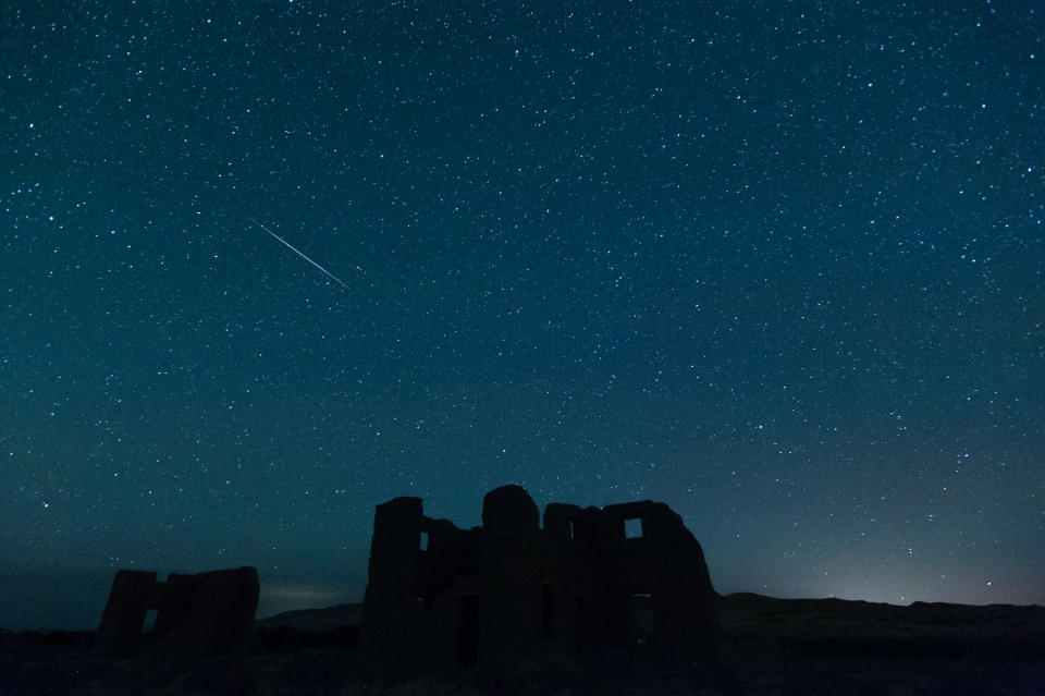 Fotografía de larga exposición que muestra a un estrella fugaz, durante la lluvia anual de las Perseidas, sobre unas ruinas al interior del Parque Estatal de Fort Churchill, el 12 de agosto de 2012, en Silver Springs, Nevada. AP Photo/Kevin Clifford