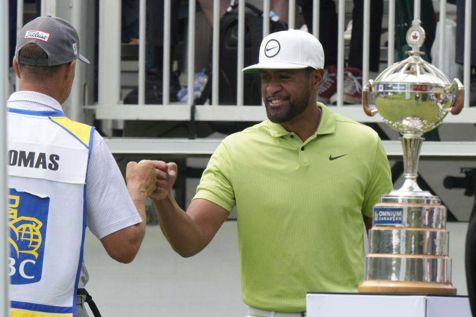 Tony Finau fist bumps with Justin Thomas's caddy Jim "Bones" Mackay before teeing off in the fourth round of the Canadian Open golf tournament in Toronto on Sunday, June 12, 2022. (Frank Gunn/The Canadian Press via AP)