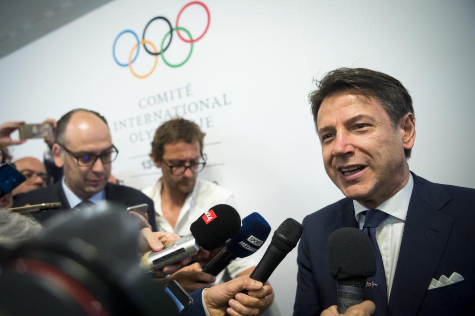 Italian Prime minister Giuseppe Conte speaks to journalists as he arrives during the first day of the 134th Session of the International Olympic Committee (IOC), at the SwissTech Convention Centre, in Lausanne, Switzerland, Monday, June 24, 2019. The host city of the 2026 Olympic Winter Games will be decided during the134th IOC Session. Stockholm-Are in Sweden and Milan-Cortina in Italy are the two candidate cities for the Olympic Winter Games 2026. (Jean-Christophe Bott/Keystone via AP)