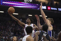 Philadelphia 76ers guard Tyrese Maxey drives to the basket past Sacramento Kings forward Domantas Sabonis, right, in the first half of an NBA basketball game in Sacramento, Calif., Monday, March 25, 2024. (AP Photo/José Luis Villegas)