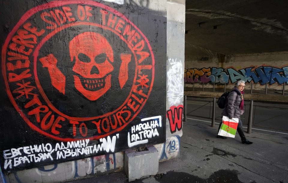 A woman walks by a repainted mural depicting the logo of Russia's Wagner Group on a wall in Belgrade, Serbia, Thursday, Jan. 19, 2023. (AP Photo/Darko Vojinovic)