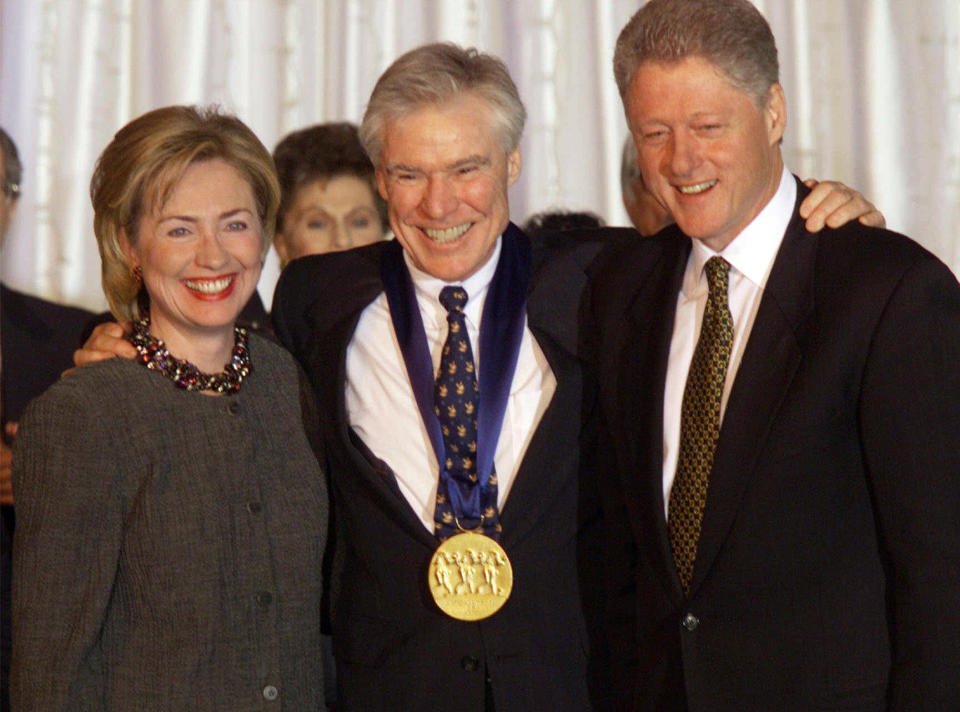 FILE - Dancer-choreographer Jacques d'Amboise poses with President Bill Clinton, right, and first lady Hillary Rodham Clinton at the White House after D'Amboise was presented with the National Medal of Arts Award on Nov. 5, 1998. D'Amboise, who grew up on the streets of upper Manhattan to become one of the world's premier classical dancers at New York City Ballet and spent the last four and a half decades providing free dance classes to city youth at his National Dance Institute, died Sunday, May 2, 2021. He was 86. His death was confirmed by Ellen Weinstein, director of the institute. (AP Photo/Doug Mills, File)