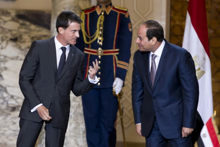 French Prime Minister Manuel Valls (L) gestures next to Egyptian president Abdel Fattah al-Sisi during a ceremony to sign military contracts at the presidential palace in Cairo on October 10, 2015