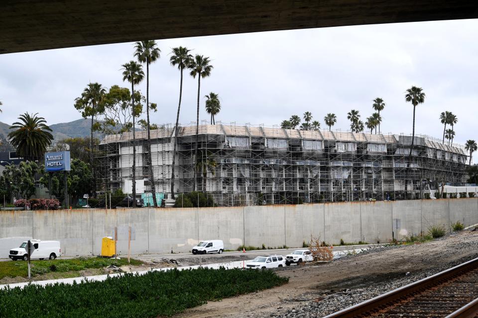 Vehicles pass along Highway 101 in Ventura below the Amanzi Hotel Thursday, where scaffolding covers the exterior for an update of the hotel's facade.