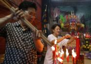 People light joss sticks during the Hungry Ghost festival in Kuala Lumpur August 3, 2014. According to Taoist and Buddhist beliefs, the seventh month of the Chinese Lunar calendar, known as the Hungry Ghost Festival is when the Gates of Hell open to let out spirits who wander the land of the living looking for food. Food offerings are made while paper money and joss sticks are burnt to keep the spirits of dead ancestors happy and to bring good luck. REUTERS/Olivia Harris (MALAYSIA - Tags: SOCIETY RELIGION)