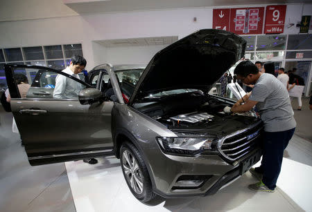 Men check a Haval H6 from Great Wall Motors during the Auto China 2016 auto show in Beijing, China May 4, 2016. REUTERS/Jason Lee