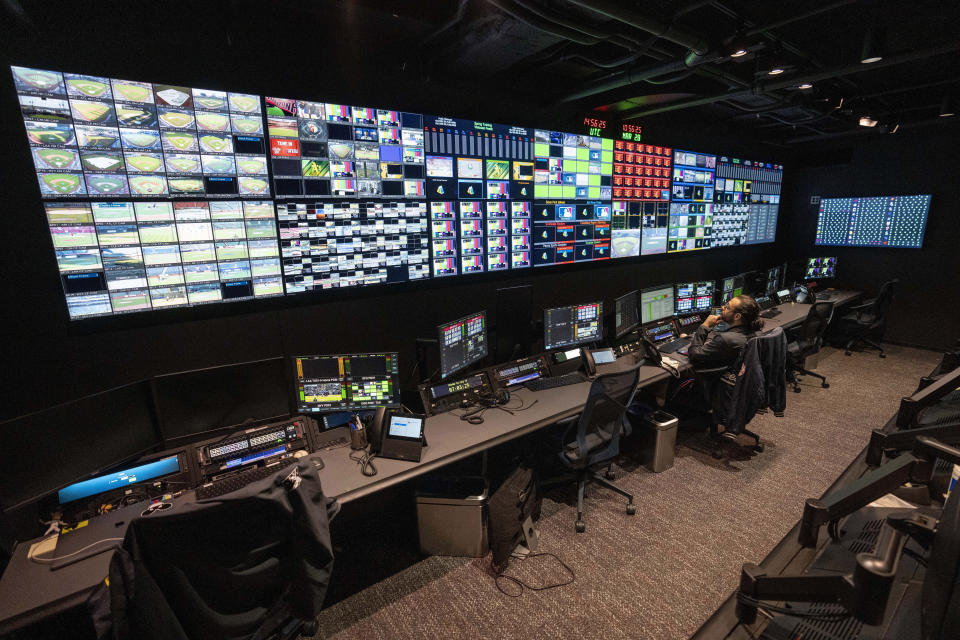 Employees operate workstations inside the broadcast support room at Major League Baseball headquarters in New York, Tuesday, March 28, 2023. (AP Photo/John Minchillo)