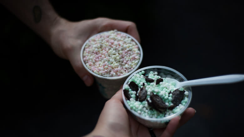 Two hands holding Dippin' Dots