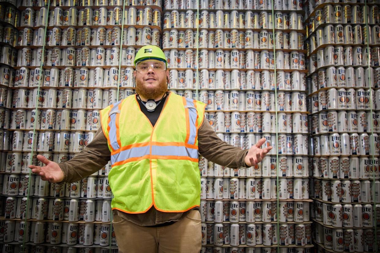 Country music superstar Luke Combs checks out the specialty packaging on cases and cans of Miller Lite at Miller Brewery in Milwaukee on April 10, 2024. The specialty packaging is tied to Combs' "Growin' Up and Gettin' Old" tour, which kicks off in Milwaukee April 12.