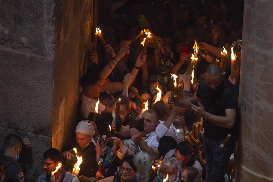 Christian pilgrims hold candles as they gather during the ceremony of the Holy Fire at Church of the Holy Sepulchre, where many Christians believe Jesus was crucified, buried and rose from the dead, in the Old City of Jerusalem, Saturday, May 1, 2021. Hundreds of Christian worshippers took use of Israel's easing of coronavirus restrictions Saturday and packed a Jerusalem church revered as the site of Jesus' crucifixion and resurrection for an ancient fire ceremony ahead of Orthodox Easter. (AP Photo/Ariel Schalit)