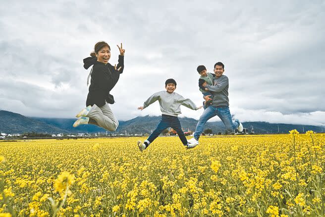 台東縣池上鄉伯朗大道今年種植90公頃油菜花，田中伯公廟成為打卡新亮點，民眾也開心留下經典跳躍照。（蔡旻妤攝）