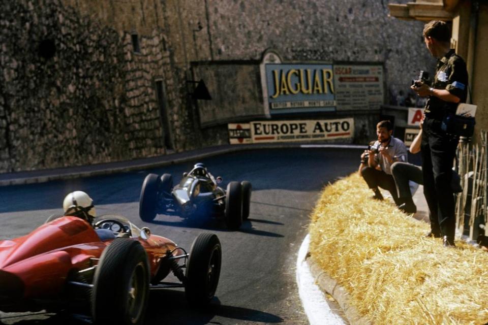 Hay bales line the streets of Monaco, as John Surtees in his Ferrari 156 chases the BRM P57 of race winner Graham Hill in May 1963.