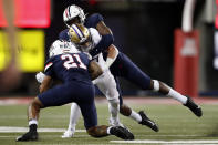 Arizona defensive lineman Jalen Harris, rear, and safety Jaxen Turner tackle Washington running back Sean McGrew during the first half of an NCAA college football game Friday, Oct. 22, 2021, in Tucson, Ariz. (AP Photo/Chris Coduto)